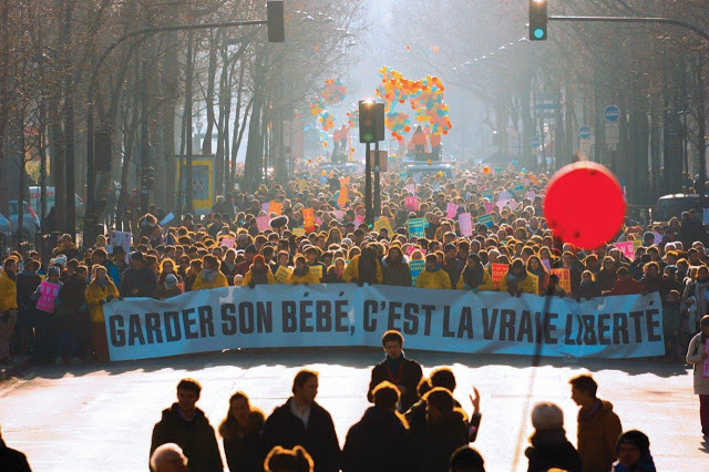 Manifestantes Pró-Vida em grande número seguram grande faixa dizendo que ter filhos é a verdadeira liberdade.