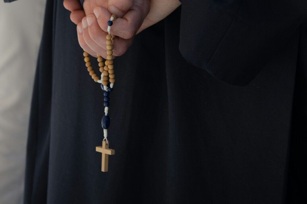 Exorcista: imagem mostra sacerdote com terço nas mãos.